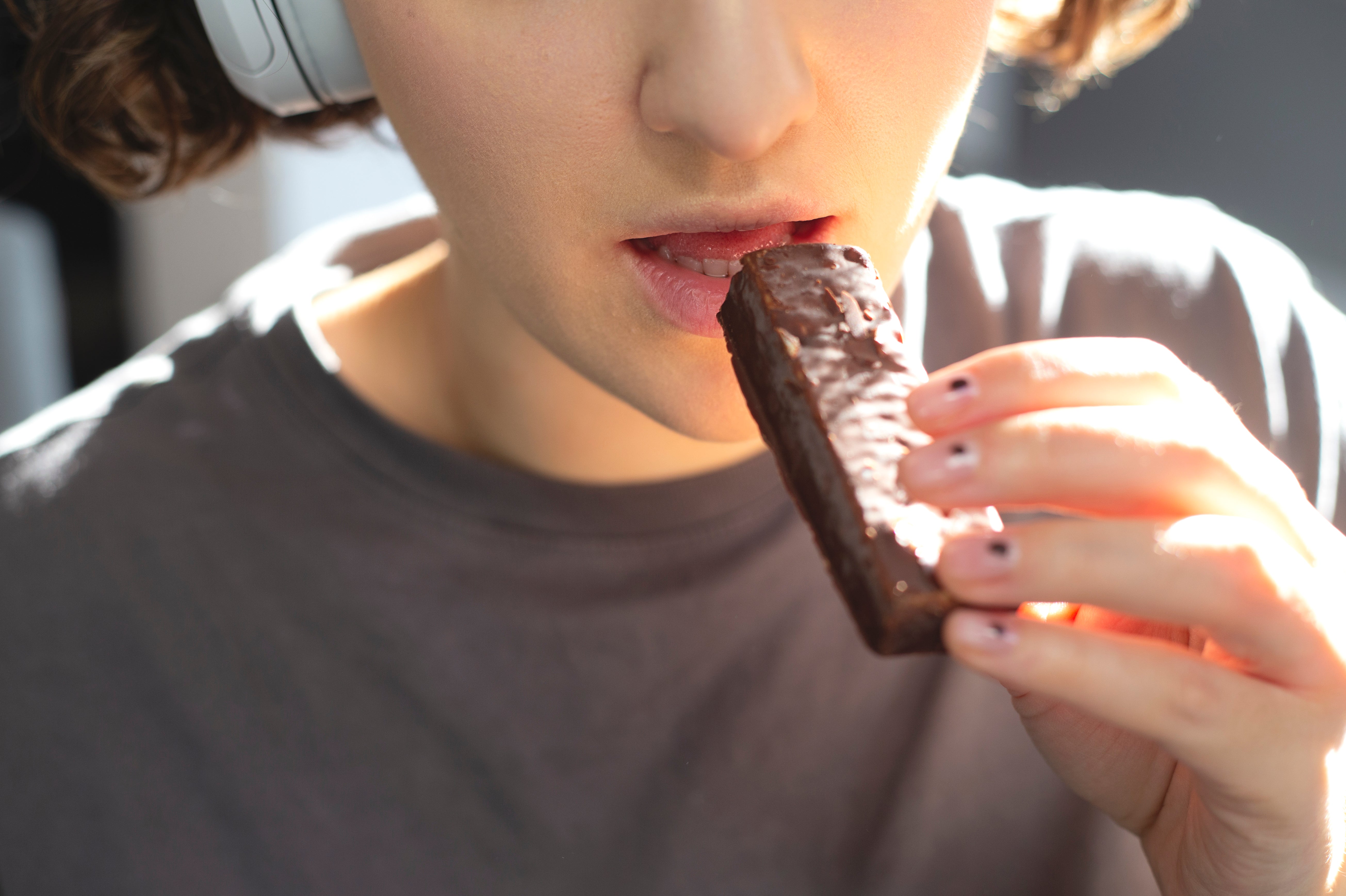 Frau isst einen Proteinriegel als Snack