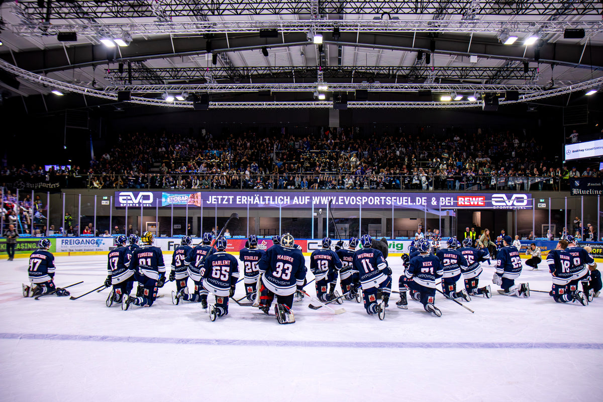 Die EC Kassel Huskies auf dem Eis, im Hintergrund EVO-Bande